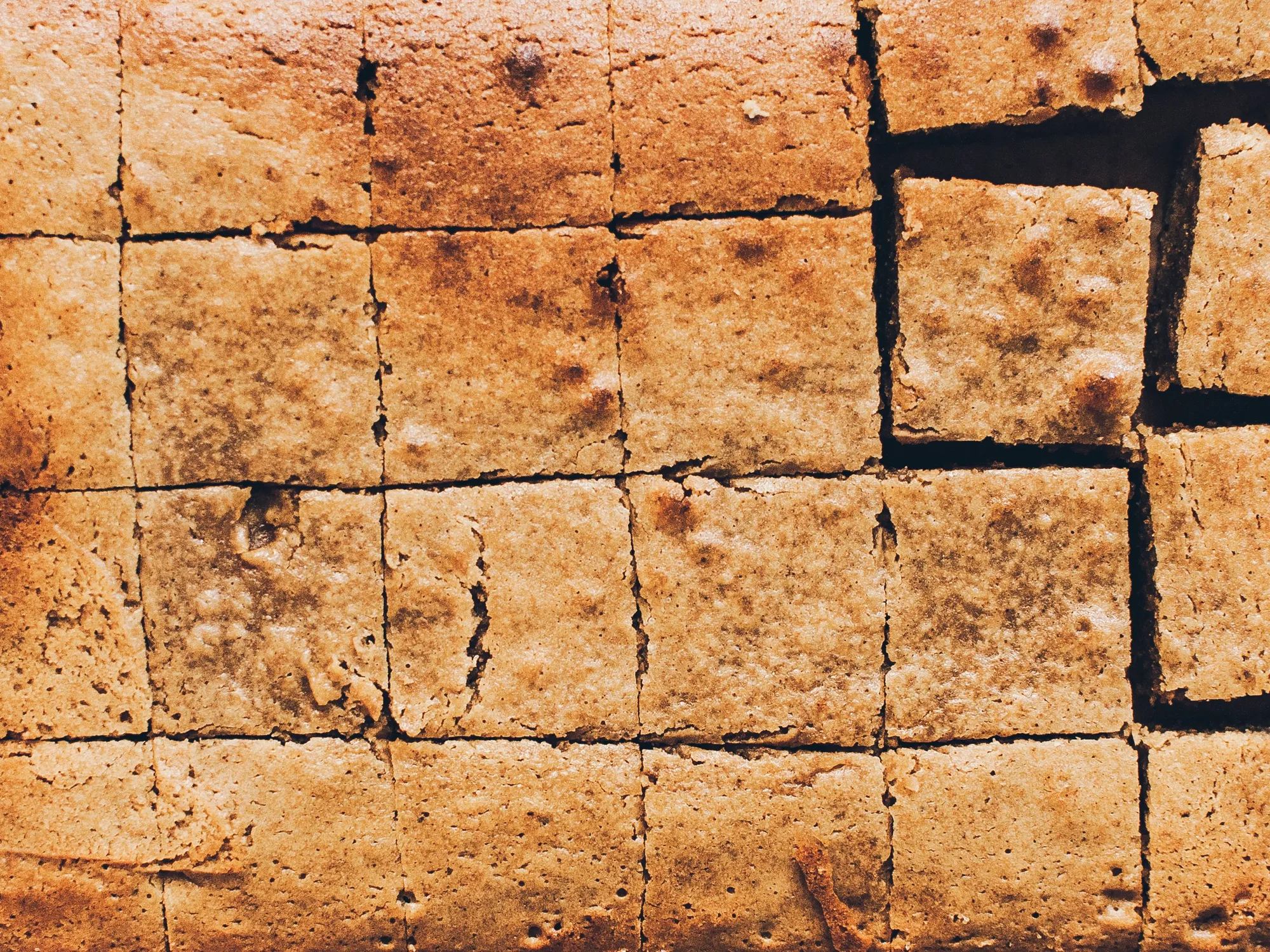 Goldbraune Blondie-Masse mit wirbelnden Spuren eines Spatels, glänzend und dicht im Backblech.