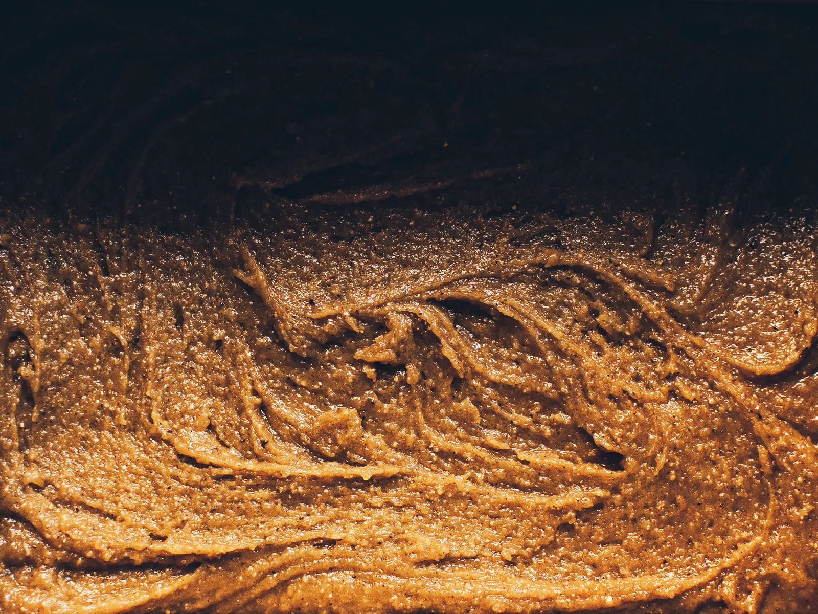 In gleichmäßige Quadrate geschnittene Blondies mit goldbraun gebackener, leicht gerissener Oberfläche, von oben fotografiert.